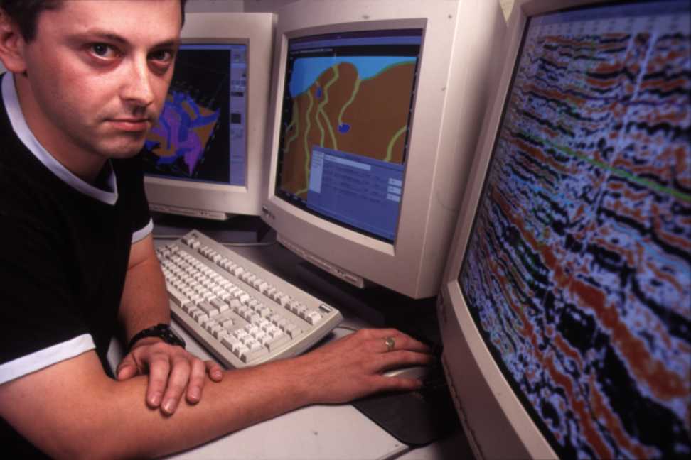 3 big CRT monitors, one with seismic data on it.